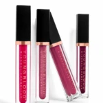Four liquid lip gloss tubes with black caps and rose-gold bands, arranged on a white background.