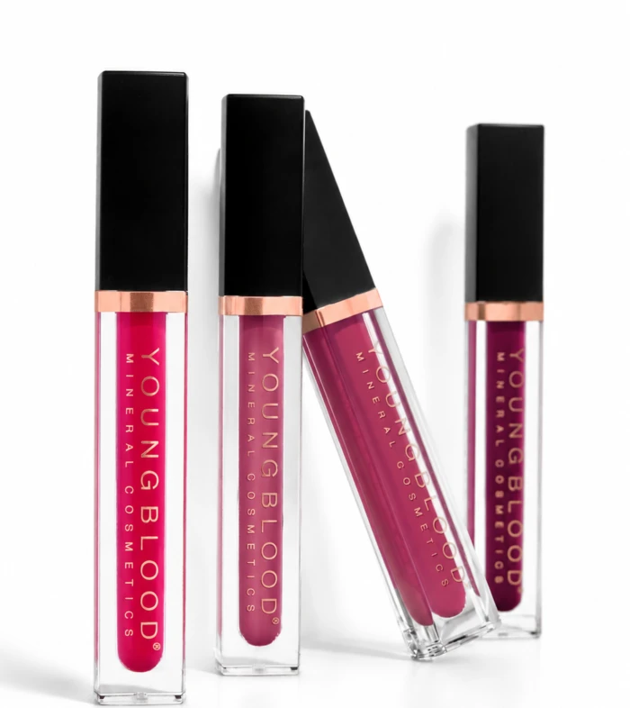 Four liquid lip gloss tubes with black caps and rose-gold bands, arranged on a white background.