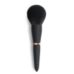 Close-up of a dense black makeup brush with a copper ferrule against a white background.