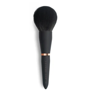 Close-up of a dense black makeup brush with a copper ferrule against a white background.