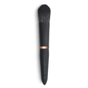 Close-up of a black makeup brush with dense bristles and a copper ferrule against a white background