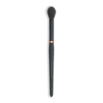 Full-length black makeup brush with dense dark bristles and a copper ring, viewed from above the bristles