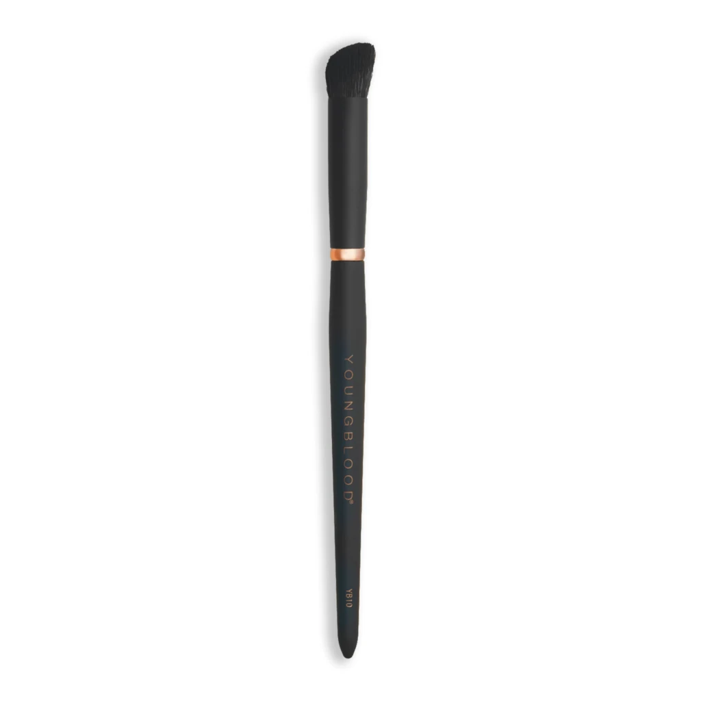 Black makeup brush with dense fluffy bristles, copper collar, and a dark handle against a white background