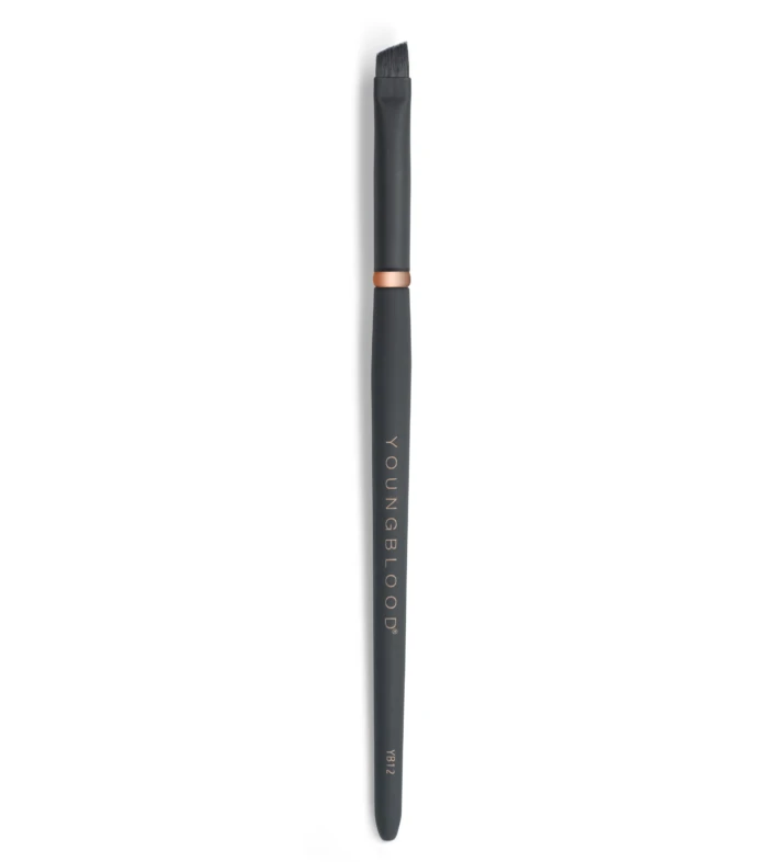 Vertical close-up of a black makeup brush with a copper ring, bristles at the top on a white backdrop.