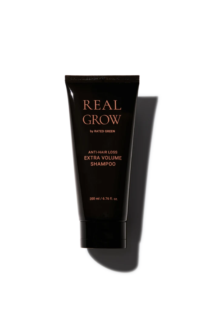 Tube of Real Grow anti-hair loss shampoo labeled 'EXTRA VOLUME'; 200 ml bottle with rose-gold text on black packaging