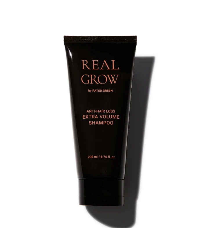 Tube of Real Grow anti-hair loss shampoo labeled 'EXTRA VOLUME'; 200 ml bottle with rose-gold text on black packaging