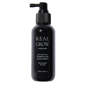 Dark spray bottle labeled REAL GROW anti-hair loss stimulating scalp spray against black background.