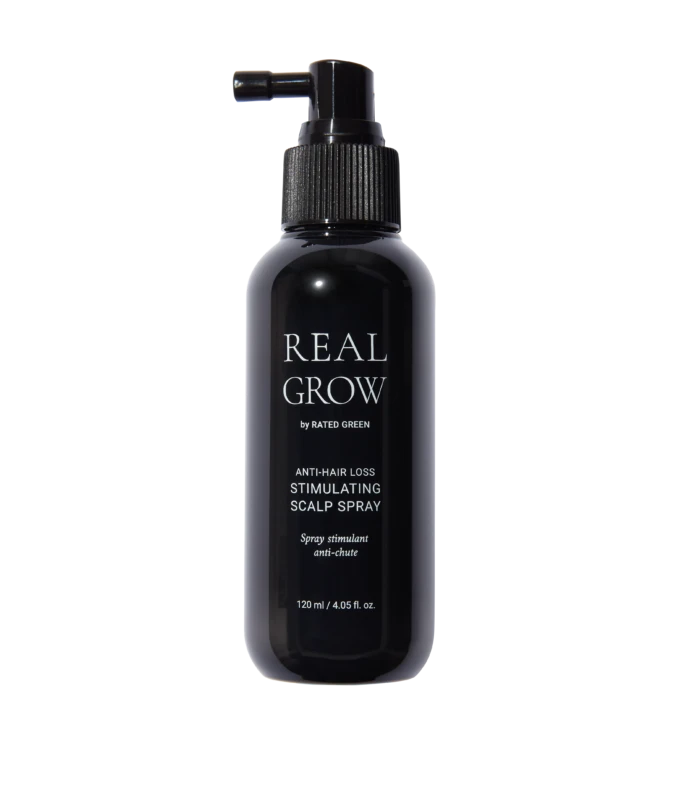Dark spray bottle labeled REAL GROW anti-hair loss stimulating scalp spray against black background.