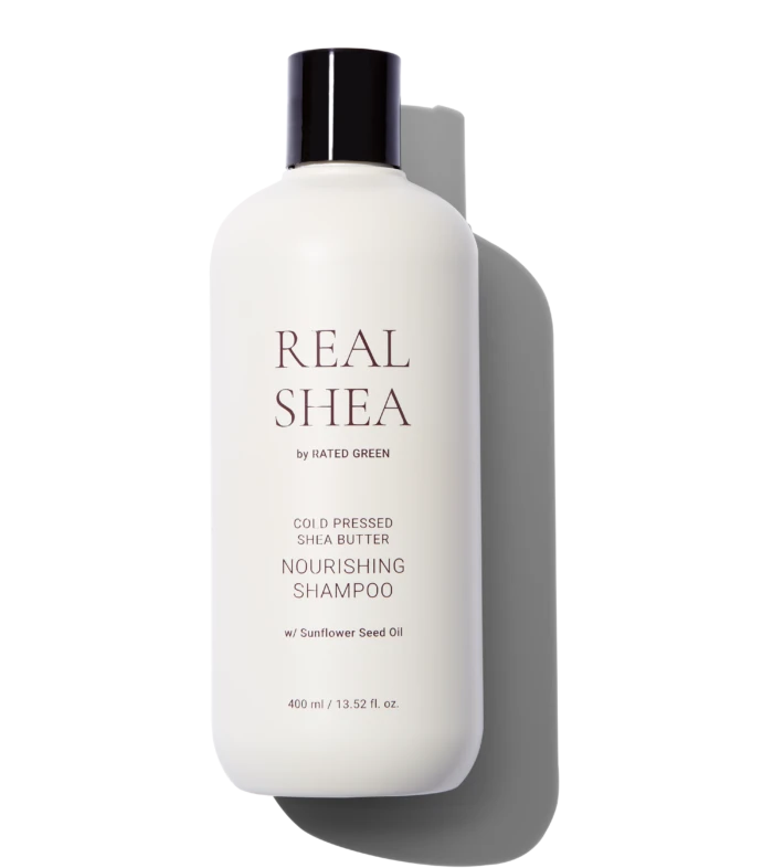 White shampoo bottle with a dark cap, labeled REAL SHEA by Rated Green, against a black background.