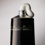 Close-up of a black spray can nozzle dispensing white foam.
