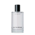 Perfume bottle with black cap and white label reading Black Rose & Oud, Salt & Stone visible at base.