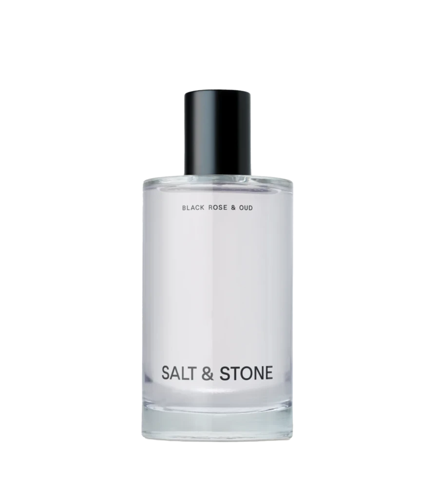 Perfume bottle with black cap and white label reading Black Rose & Oud, Salt & Stone visible at base.