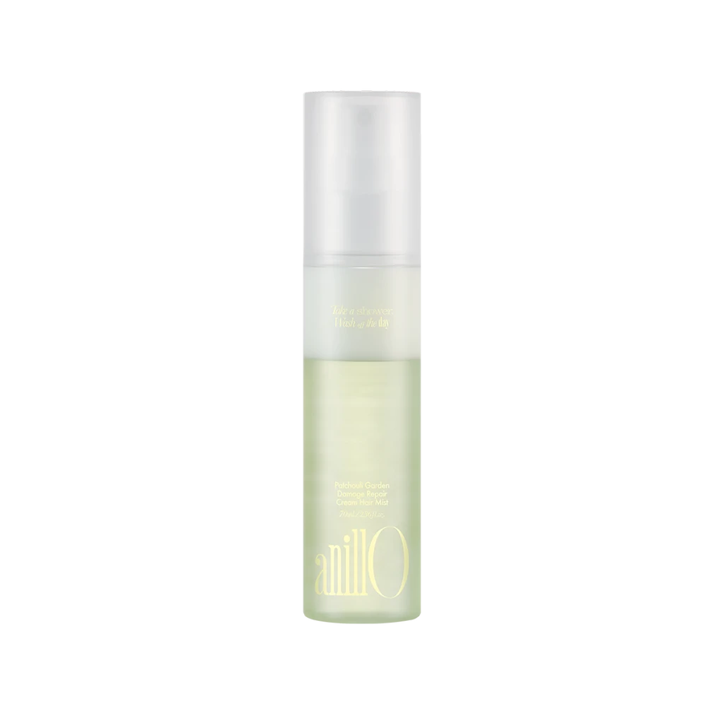 Tall frosted spray bottle with pale green liquid, labeled Patchouli Garden Damage Repair Cream Hair Mist.