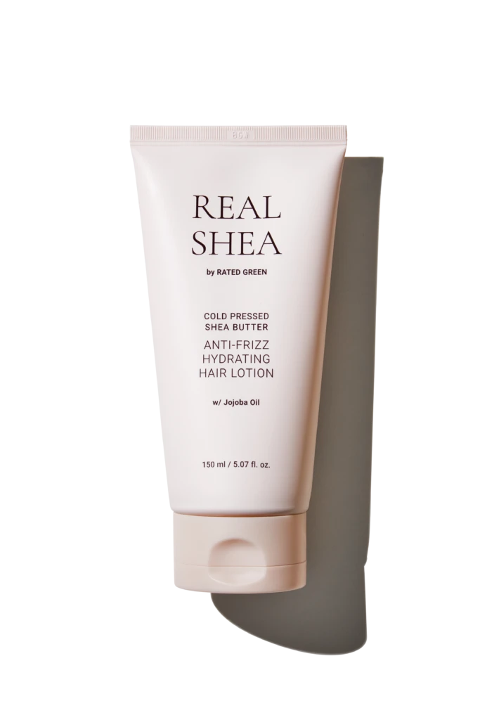 Tube of Real Shea anti-frizz hydrating hair lotion with jojoba oil, pale pink packaging in a vertical pose (150 ml).