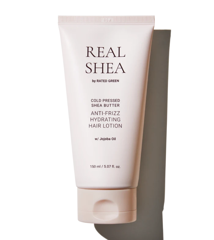 Tube of Real Shea anti-frizz hydrating hair lotion with jojoba oil, pale pink packaging in a vertical pose (150 ml).