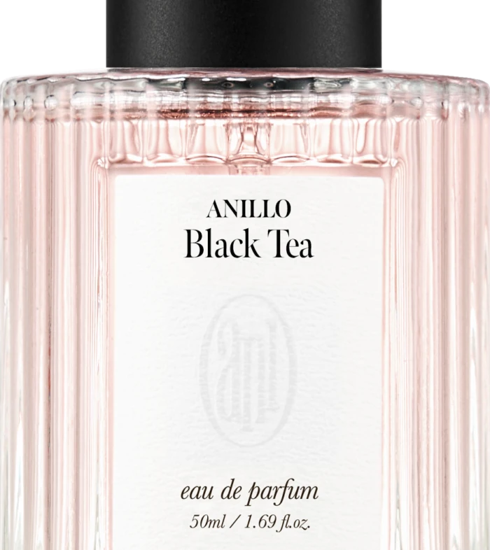 Front view of a pale pink perfume bottle with a black cap, label reads ANILLO Black Tea, eau de parfum 50 ml.
