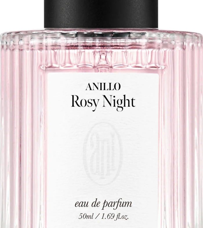 Close-up of a pink ribbed perfume bottle with a black cap; label reads ANILLO Rosy Night, eau de parfum, 50 ml.