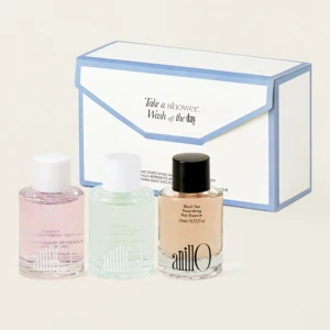 Three pastel nail polish bottles (pink, mint, nude) sit in front of a white and blue boxed set with an envelope design, suggesting a gift set.