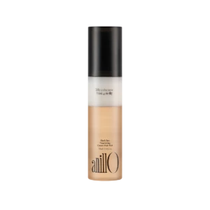 Bottle of AnillO Black Tea Nourishing Cream Hair Mist with a black cap and beige-tinted liquid at the base