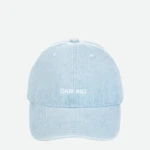 Close-up of a light blue denim cap from above, showing the top button and stitched panels with the word 'DARLING' on the back.