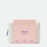 Soft cream-colored plush toy (sheep) with a pink rectangular box/card labeled DARLING and MULTI-BIOTICS against a light background.