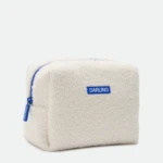 Close-up of a cream sherpa towel with a blue zipper and a blue label reading DARLING