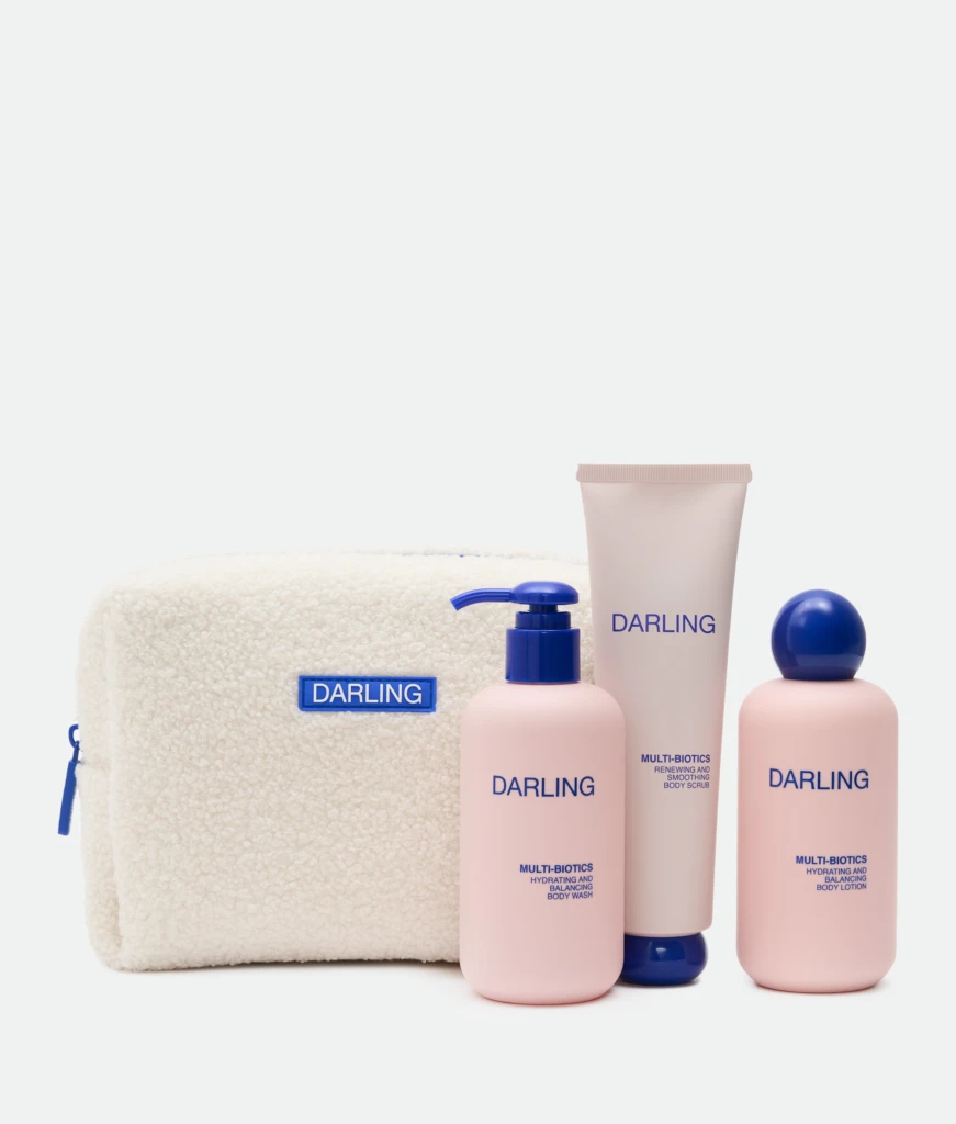 Products from the Darling brand arranged with a beige towel in the background; includes pink bottles with blue caps and a Pump dispenser, text visible on bottles.