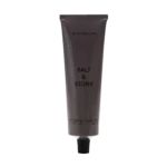 Vertical gray lotion tube labeled 'BLACK ROSE & OUD' with a black ribbed cap, set against a black background.