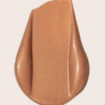 Shimmery copper lipstick swatch spread on a light beige background, glossy and metallic in finish