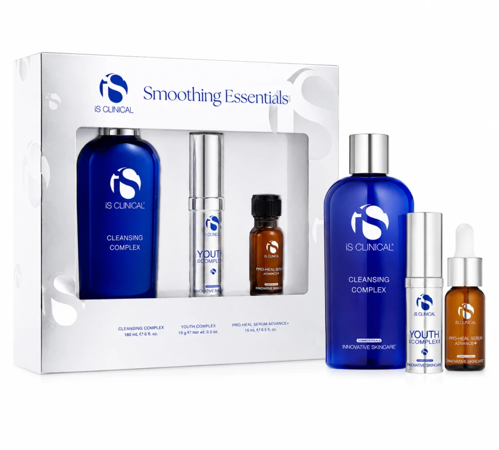 Boxed iS CLINICAL Smoothing Essentials skincare set with blue cleansing complex bottle and smaller serums visible beside the box, on a white background.