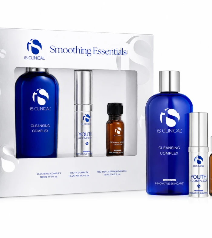 Boxed iS CLINICAL Smoothing Essentials skincare set with blue cleansing complex bottle and smaller serums visible beside the box, on a white background.