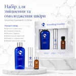 IS CLINICAL Smoothing Essentials skincare kit displayed on a marble surface, featuring a blue cleansing bottle and smaller serums in front.