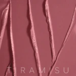 Close-up of glossy pink ribbons or folds on a pink background, with the word TIRAMISU faintly visible at the bottom.