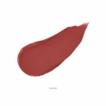 Swatch of lipstick in shade Smolder—a warm red-brown smear on a white background.