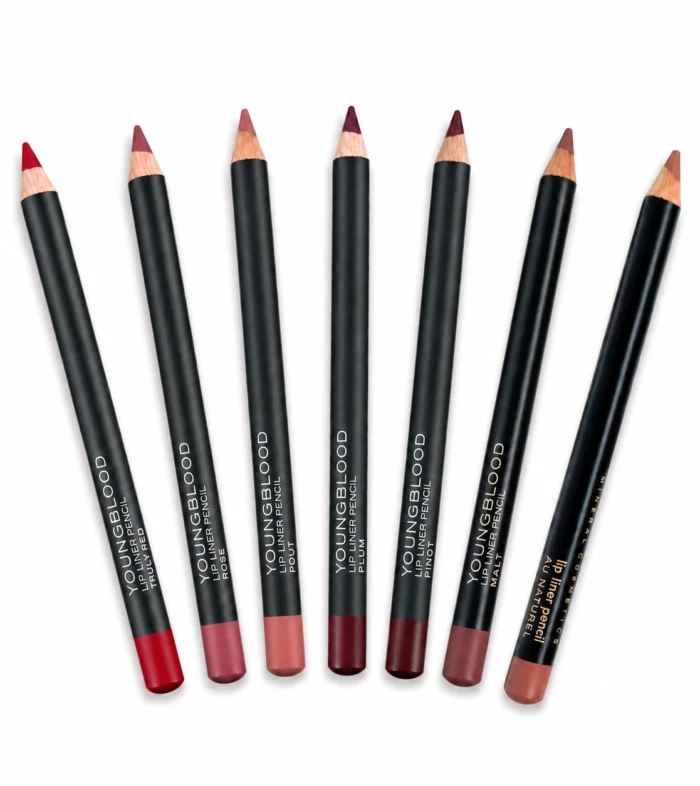 Seven black lip liner pencils with pink-nude to burgundy shades arranged diagonally on a white background.