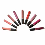 Assorted Youngblood lip gloss tubes arranged in a curved arc on a white background, showing various pinks, reds, and nudes.