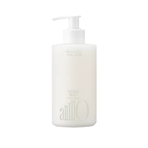 White shampoo bottle with a pump dispenser, featuring faint printed text on the label.