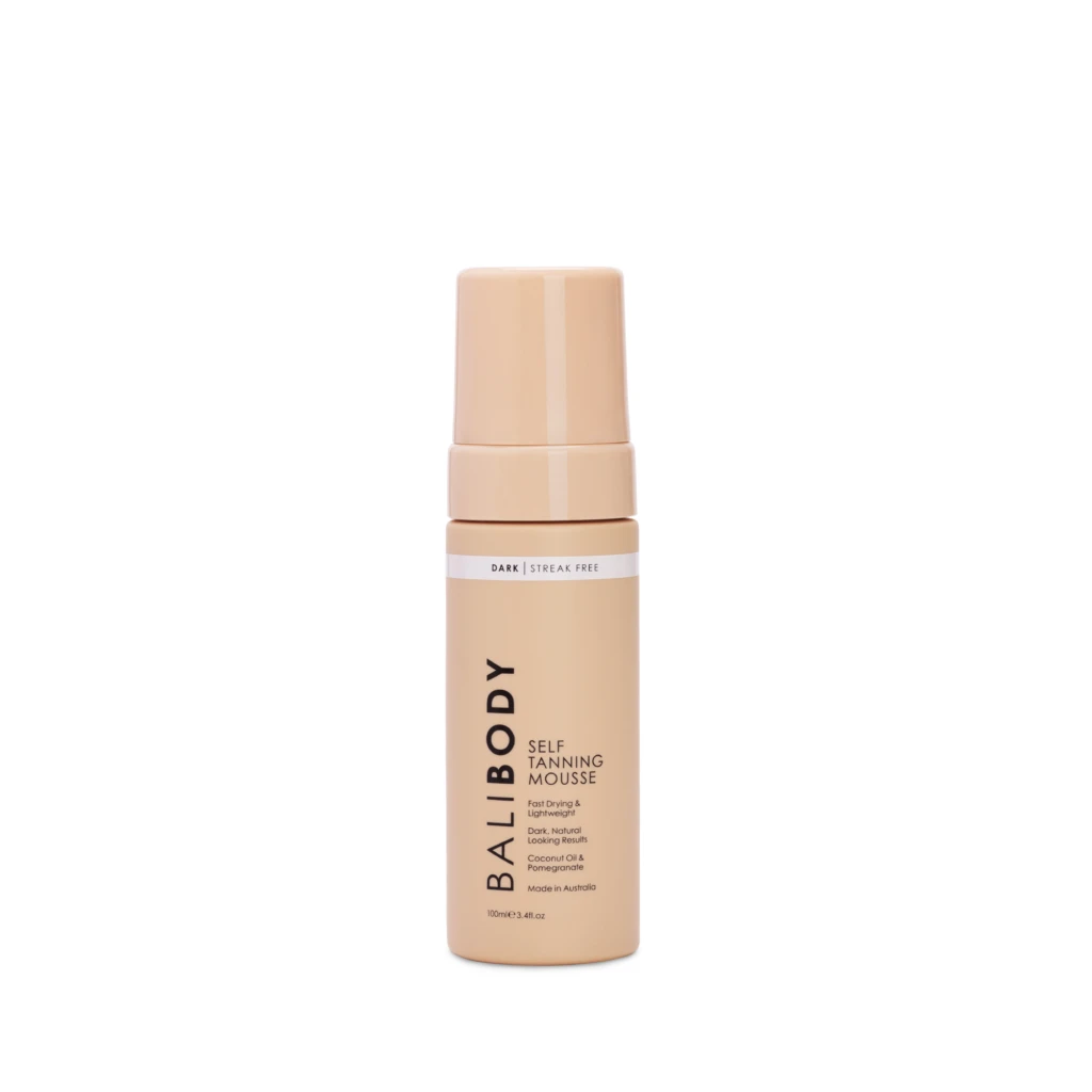 Peach-colored self-tanning mousse bottle with pump top, showing the label 'Dark Streak Free' and 'Self Tanning Mousse' on a white background