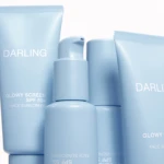 Close-up of pastel blue sunscreen bottles with the word DARLING printed on them.