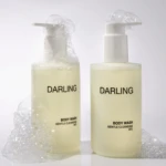 Two white pump bottles labeled DARLING Body Wash with clear bubbles around the pumps against a light background.