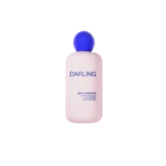 Pink bottle of Darling Multi-Biotics hydrating and balancing body lotion with a blue cap against a black background