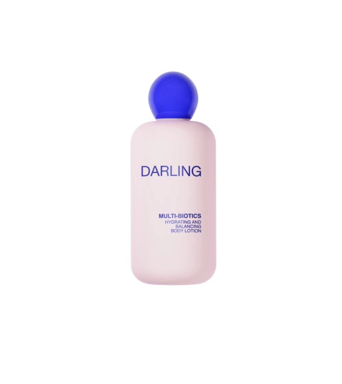 Pink bottle of Darling Multi-Biotics hydrating and balancing body lotion with a blue cap against a black background