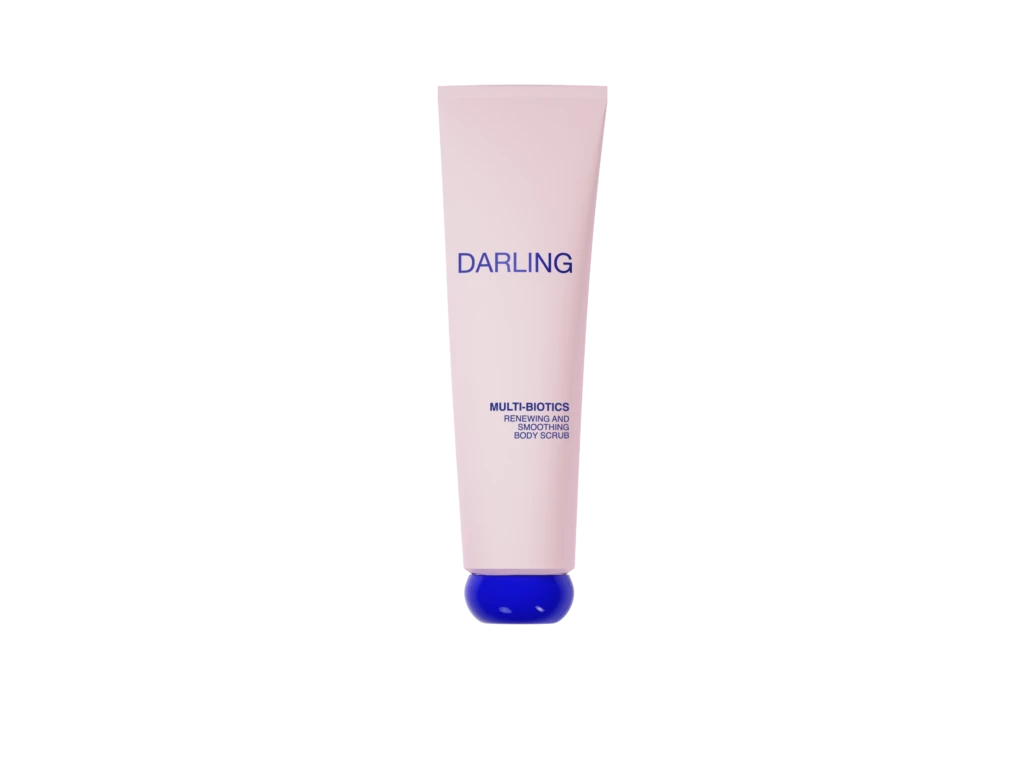 Pink cylindrical tube labeled DARLING with a blue cap at the bottom, advertising Multi-Biotics Renewing and Smoothing Body Scrub against a black background.