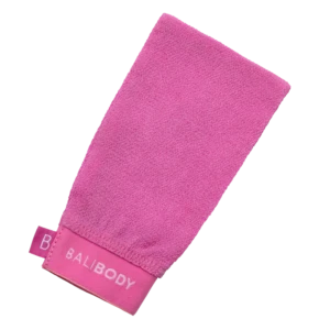 Pink terry-cloth towel folded diagonally on a white background, showing its textured surface and edge tag.