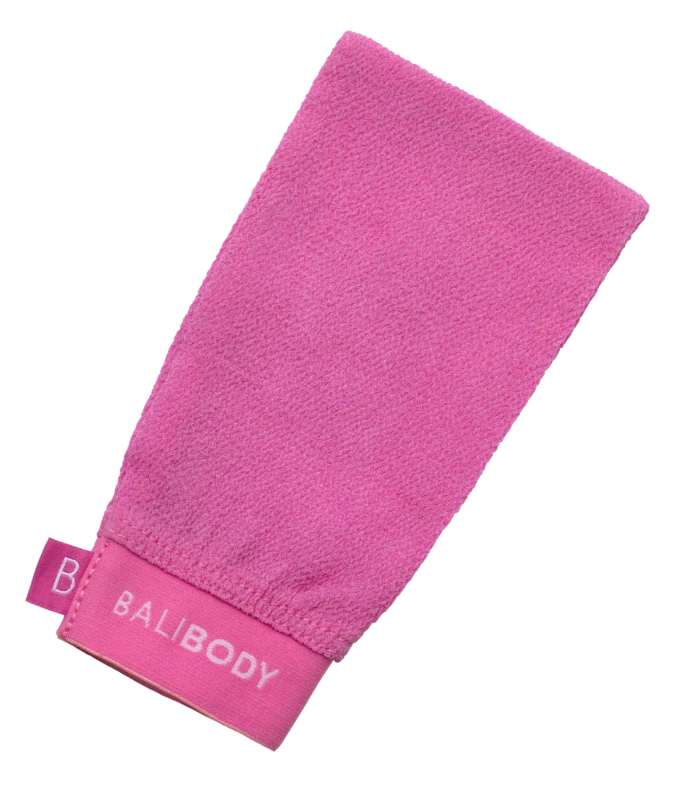 Pink terry-cloth towel folded diagonally on a white background, showing its textured surface and edge tag.