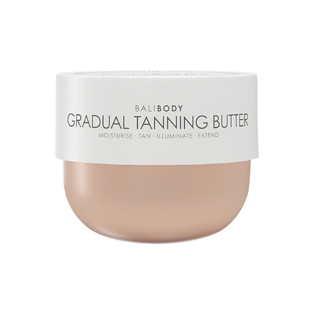 Close-up of a white cosmetic jar displaying the text 'BALI BODY GRADUAL TANNING BUTTER' with beige lotion visible at the bottom edge, indicating a tanning product.