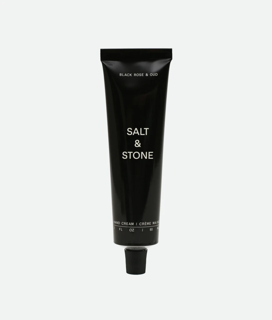Tall black Salt & Stone hand cream tube with white text, photographed vertically.