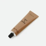 Beige lipstick tube diagonally positioned on a white background, with the brand name Salt & Stone visible on the packaging.