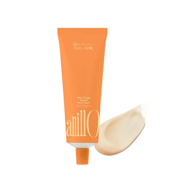 Orange squeeze tube of hand cream with white text on the front, standing upright on a white background.
