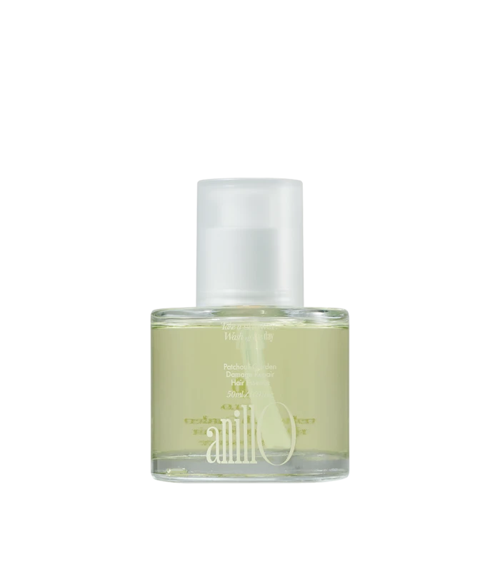 Perfume bottle with pale yellow liquid and a white spray cap on a white background, angled to the left.